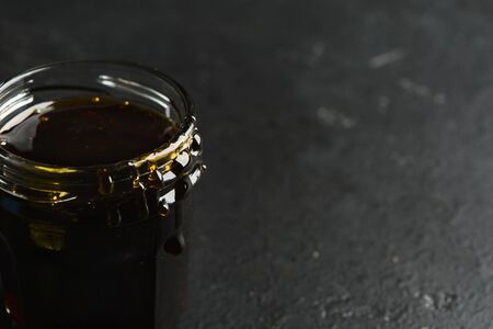 Closeup view of dark buckwheat healthy organic honey. Black stone background. Soft focus. Copy spaceの写真素材
