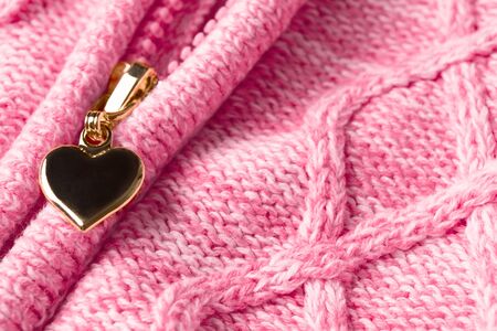 Slider with shape of heart in zipper on textile woolen pink clothes. Valentine's day material background. Love concept. Abstract love signの写真素材