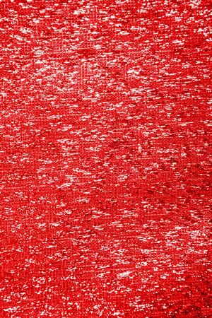 Red shiny glitter textured textile background with glow. Closeup view. Valentine's day decoration backdropの写真素材