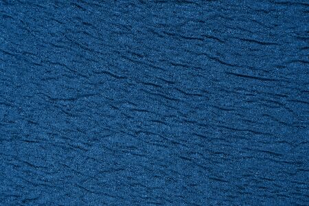 Classic blue textured material textile background. Trendy color of 2020. Wavy fabric backdropの写真素材