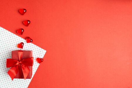 Elegant gift box with beautiful bow on wrapping paper with hearts. Copy space. Present for Valentine's day or engagment. Love conceptの写真素材