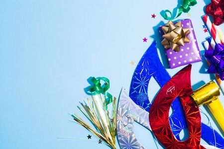 Colorful holiday background with party accessories on blue background. Copy space. Hard light. Flat layの写真素材