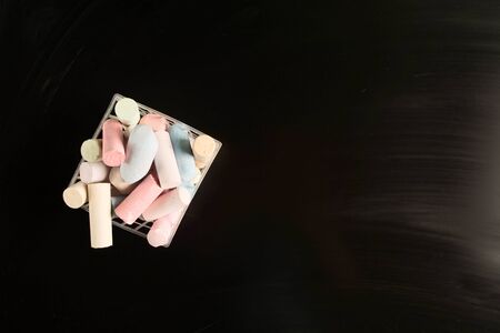 Many pieces of chalk in basket over blackboard. Top view. Copy space. Flat layの写真素材