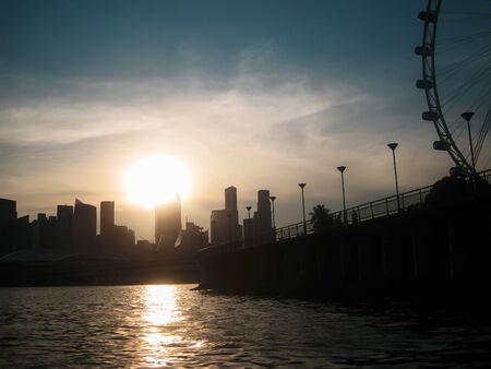Beatiful sunset with sky and silhouette of city and ferris wheel. View from Bay. Singaporeの写真素材