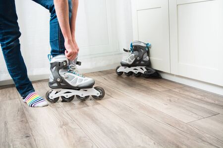Young woman wearing new roller skates at home. Sport activity at home in quarantine time. Copy space. Isolationの写真素材