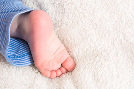 Caucasian human baby little sweet foot on soft white plaidの写真素材