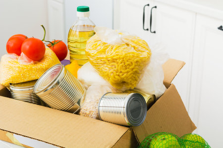 Open donation box with food in kitchen. Help for people. Charity conceptの写真素材