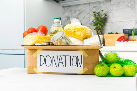 Open donation box with food in kitchen. Help for people. Charity conceptの写真素材