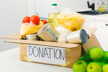 Open donation box with food in kitchen. Help for people. Charity conceptの写真素材