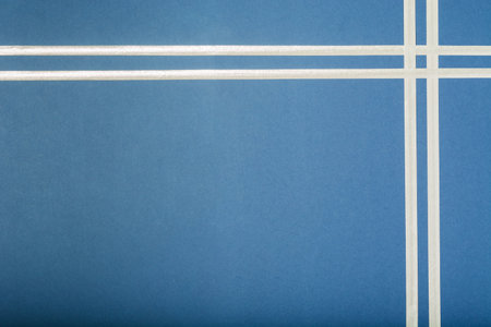 Blue holiday background for gift with silver ribbon in corner. Top view