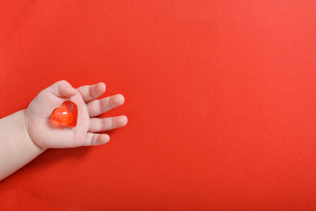 Child holding glass heart. Family, love and health conceptの写真素材