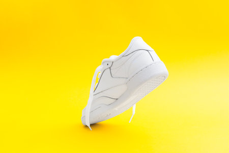 Womens stylish white sneaker on yellow background Heel counter of sport shoeの写真素材