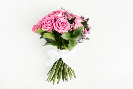 Beautiful bouquet of pink roses flowers with white bow for holiday giftの写真素材