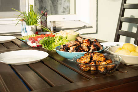 Picnic outside with barbeque meet and fresh vegetables in summer time