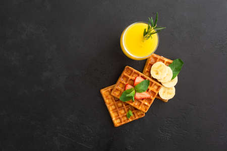 Belgium waffles with strawberry, banana with mint and honey with fresh juiceの写真素材