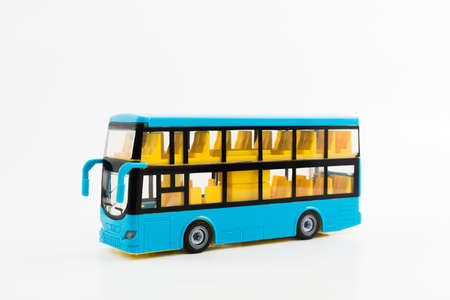 Small blue plastic touristic double-decker bus toy with yellow seats on whiteの写真素材