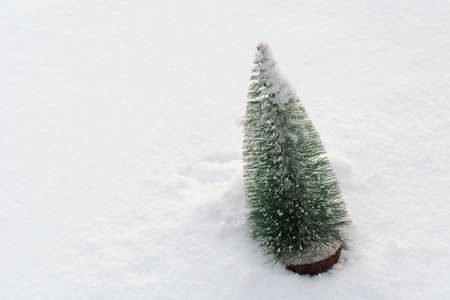 Plastic christmas tree on real snow with copy space. Winter holiday backgroundの写真素材