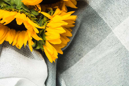 Beautiful bouquet of authentic yellow sunflowers on grey plaid. Closeup viewの写真素材