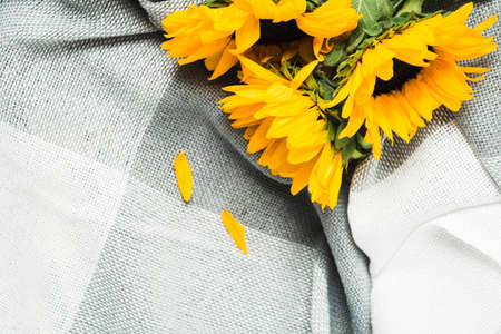 Beautiful bouquet of authentic yellow sunflowers on grey plaid. Closeup viewの写真素材