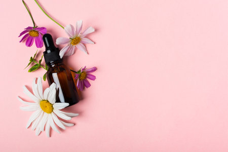 Cosmetic oil or perfume or medication in brown glass with pipette and flowersの写真素材