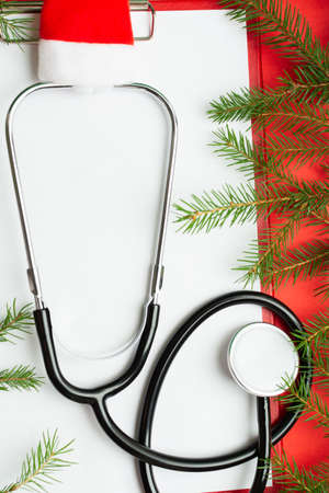 Medical Christmas concept with stethoscope in Santas hat and blank clipboardの写真素材