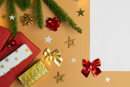 Christmas background with blank white paper , gift boxe, bows, fir tree on beigeの写真素材