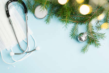 Christmas medical concept with stethoscope, face mask and christmas tree on blueの写真素材