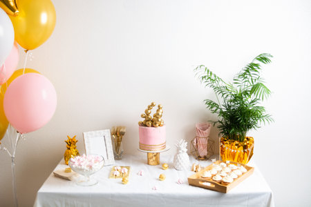 Holiday birthday table with cake and ballons. Pink and golden decorationの写真素材