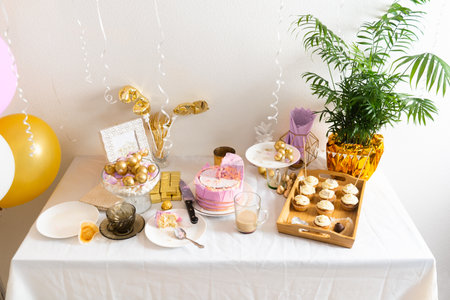 Table with leftovers after birthday with coffee, cake, cupcakesの写真素材