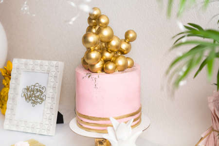 Holiday birthday table with cake and ballons. Pink and golden decorationの写真素材