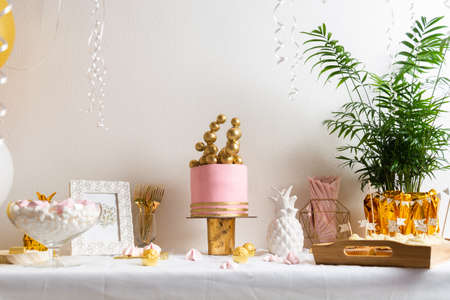 Holiday birthday table with cake and ballons. Pink and golden decorationの写真素材