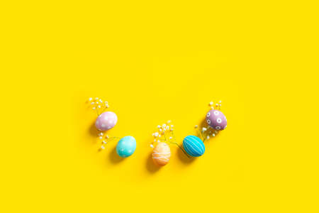 Easter flat lay composition with colorful painted natural eggs and flowersの写真素材