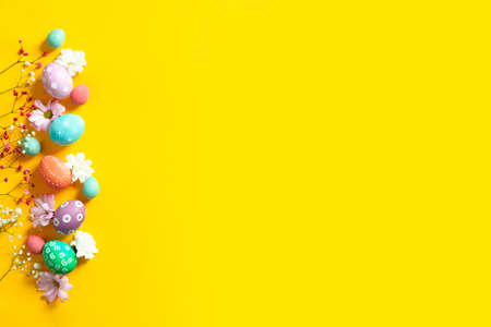 Easter beautiful flat lay with copy space with colorful eggs and flowersの写真素材