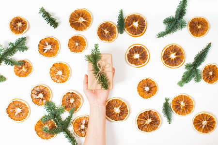Holiday gift in craft paper with decoration in female hand. Flat lay. Christmasの写真素材