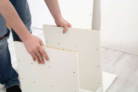 Assembly cabinet furniture. Do it youself concept. White chipboard interiorの写真素材