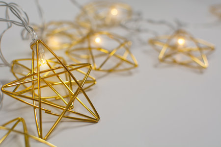 Golden metal garland with lights on gray background with copy spaceの写真素材
