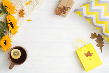 Autumn flat lay with empty space in center, tea, sunflowers and gift in cozy homeの写真素材