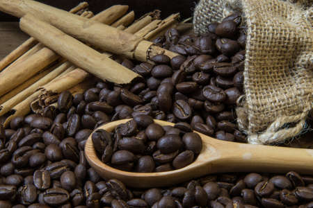 coffee beans and cinnamon on wooden table on black backgroundの写真素材