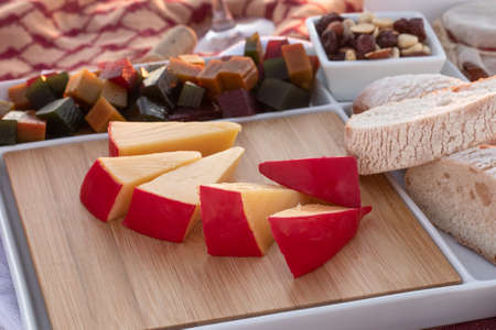 gouda cheese accompanied by pieces of bread, ate and seedsの写真素材