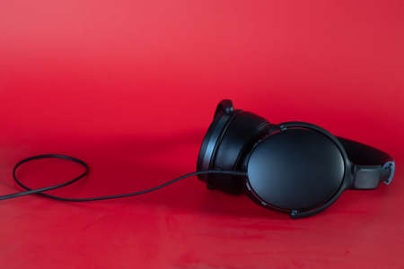 black headphones isolated on red background with copy spaceの写真素材