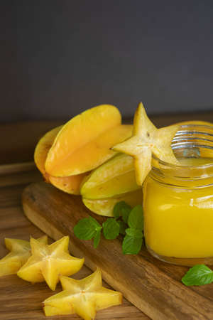Diet and refreshing juice of star fruit, carambola or star fruit, accompanied by fresh fruits on wooden table.の写真素材