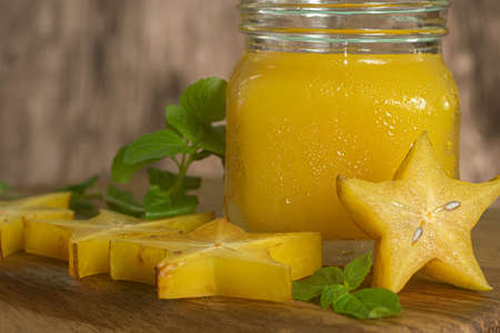 Diet juice of star fruit, carambola or star fruit, accompanied by fresh fruits on wooden table.の写真素材