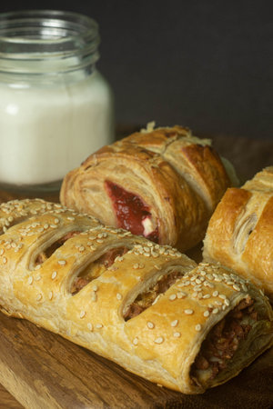 filled puff pastry dessert, accompanied by a glass of milk on a wooden boardの写真素材