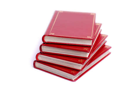 Four red books stacked up against white backgroundの写真素材