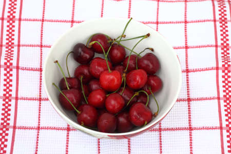 Bowl of fresh cherries on dishclothの写真素材