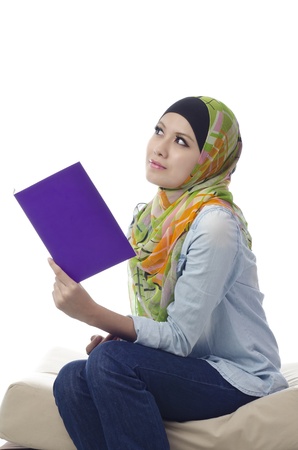 Beautiful young muslim woman reading and thinkingの写真素材