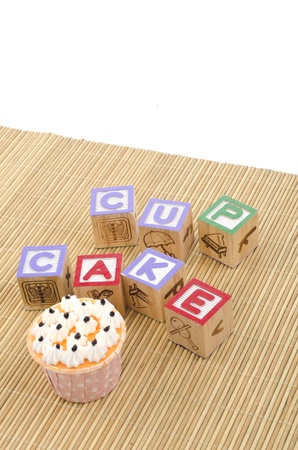 colorfull cup cake with wood blocks on bamboo matの写真素材
