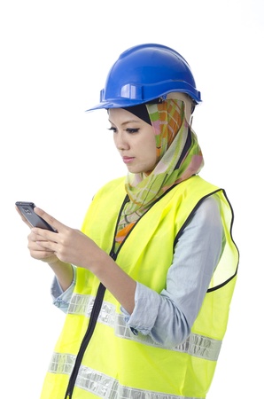Beautiful muslim woman with personal protective equipment send message using phoneの写真素材