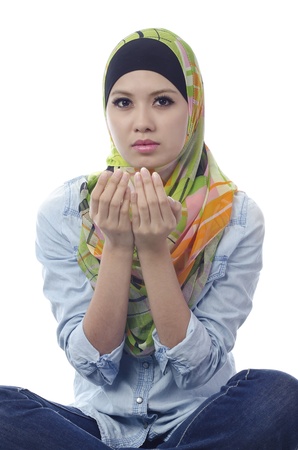 Pretty young muslim woman praying in action.の写真素材