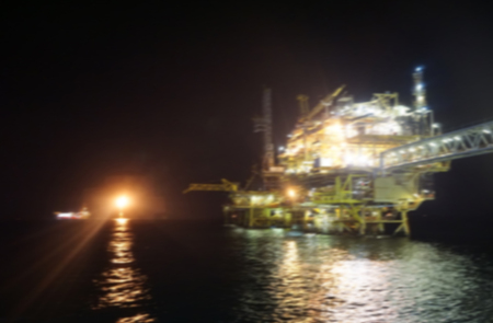 Motion blur of offshore oil and gas rig platform in the middle of South China Sea at night scene.Construction of production process in the sea. Power energy of the world.の写真素材
